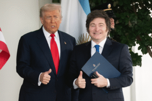 Donald Trump e Javier Milei posam juntos na Casa Branca, sorrindo e fazendo sinal de positivo diante das bandeiras dos Estados Unidos e da Argentina.