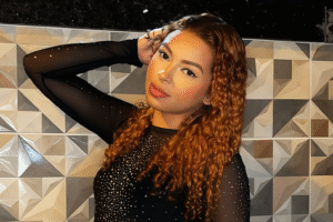 Mulher conhecida como “Japinha do CV” posa para foto com roupa preta brilhante, em imagem obtida de fonte pública e utilizada para fins jornalísticos e informativos.