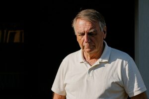 Imagem gerada por inteligência artificial, inspirada em foto publicada pelo SBT News, retratando Jair Bolsonaro em frente a uma residência durante período de prisão domiciliar.