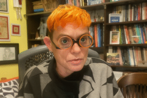 Retrato da pesquisadora Jacqueline Muniz, especialista em segurança pública, em ambiente de escritório com estante de livros ao fundo. Imagem otimizada por IA para fins jornalísticos.