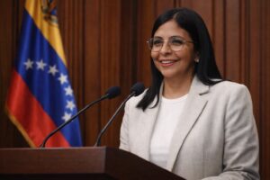 Delcy Rodríguez discursa em púlpito no Supremo Tribunal de Justiça da Venezuela, com bandeira nacional ao fundo.