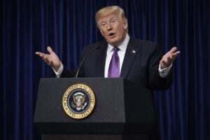 Donald Trump discursando em púlpito oficial da Casa Branca com selo presidencial ao centro.