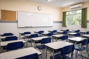 Sala de aula vazia de escola pública brasileira, com carteiras azuis e lousa branca ao fundo, imagem gerada por IA para contextualização jornalística.
