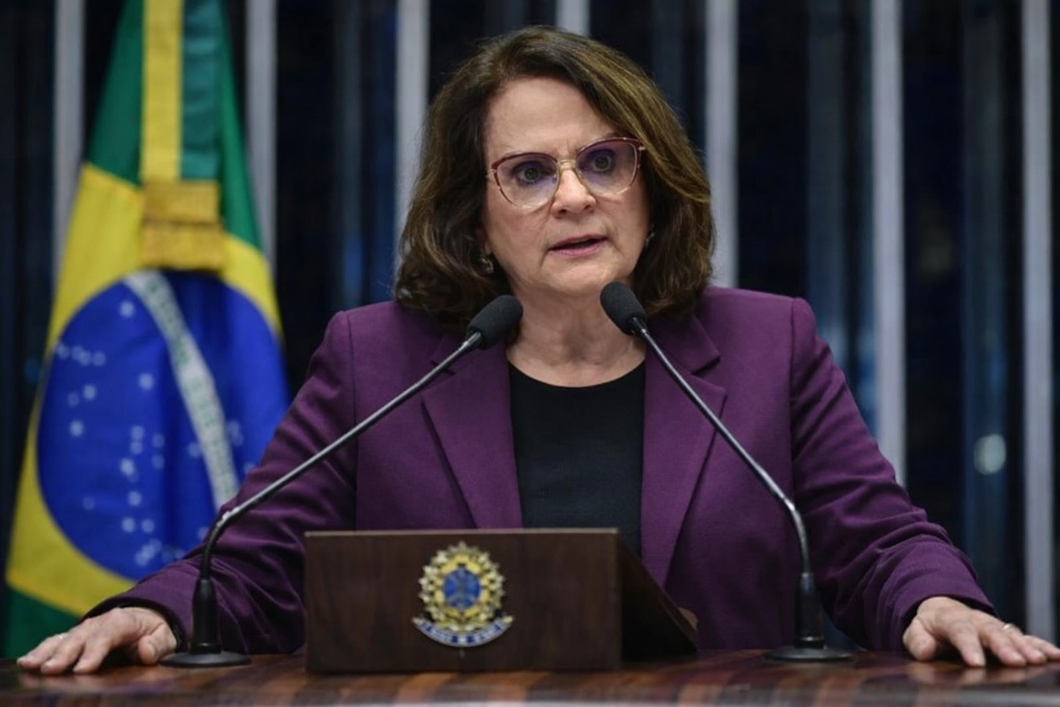 Senadora Damares Alves discursa no plenário do Senado Federal, usando blazer em tom lilás e blusa preta, em frente ao púlpito oficial.