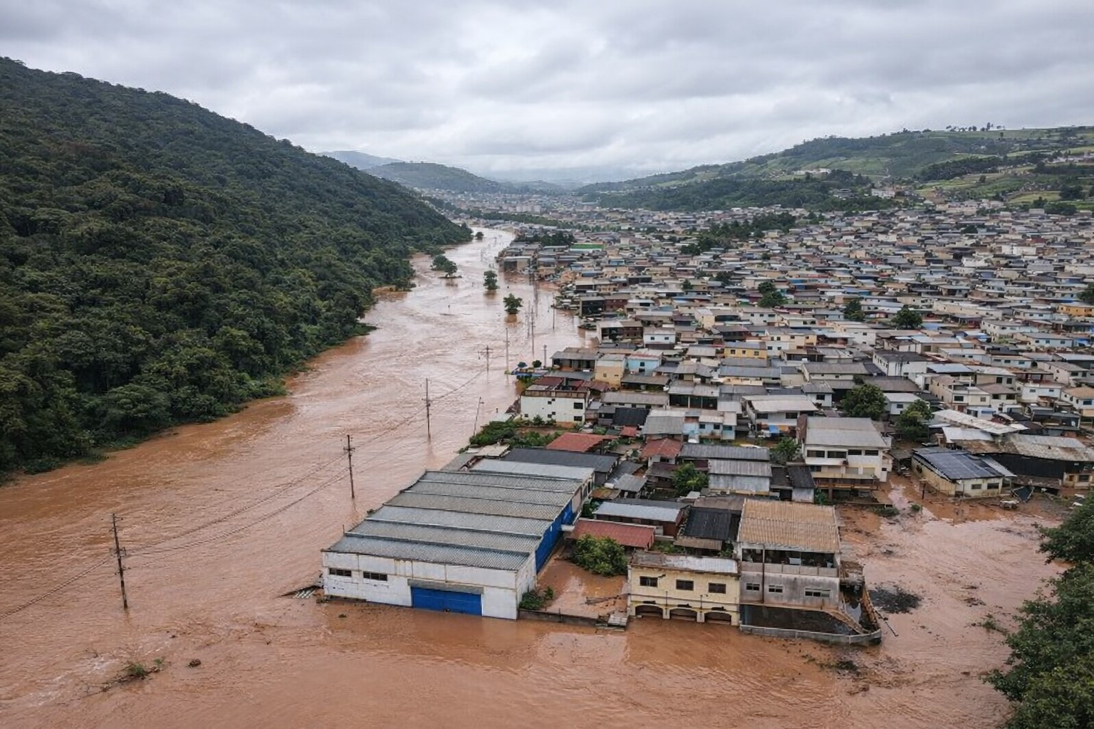 Vista aérea diagonal de bairro com casas parcialmente alagadas por água barrenta em Juiz de Fora, imagem ilustrativa gerada por inteligência artificial com base em referência real.