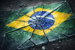 Bandeira do Brasil representada de forma simbólica em superfície rígida quebrada, ilustrando a percepção internacional sobre corrupção no país.