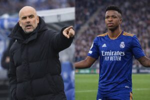 Montagem fotográfica gerada por inteligência artificial mostra Pep Guardiola à esquerda apontando à beira do campo e Vinícius Júnior à direita com uniforme azul do Real Madrid, em cenário de estádio.