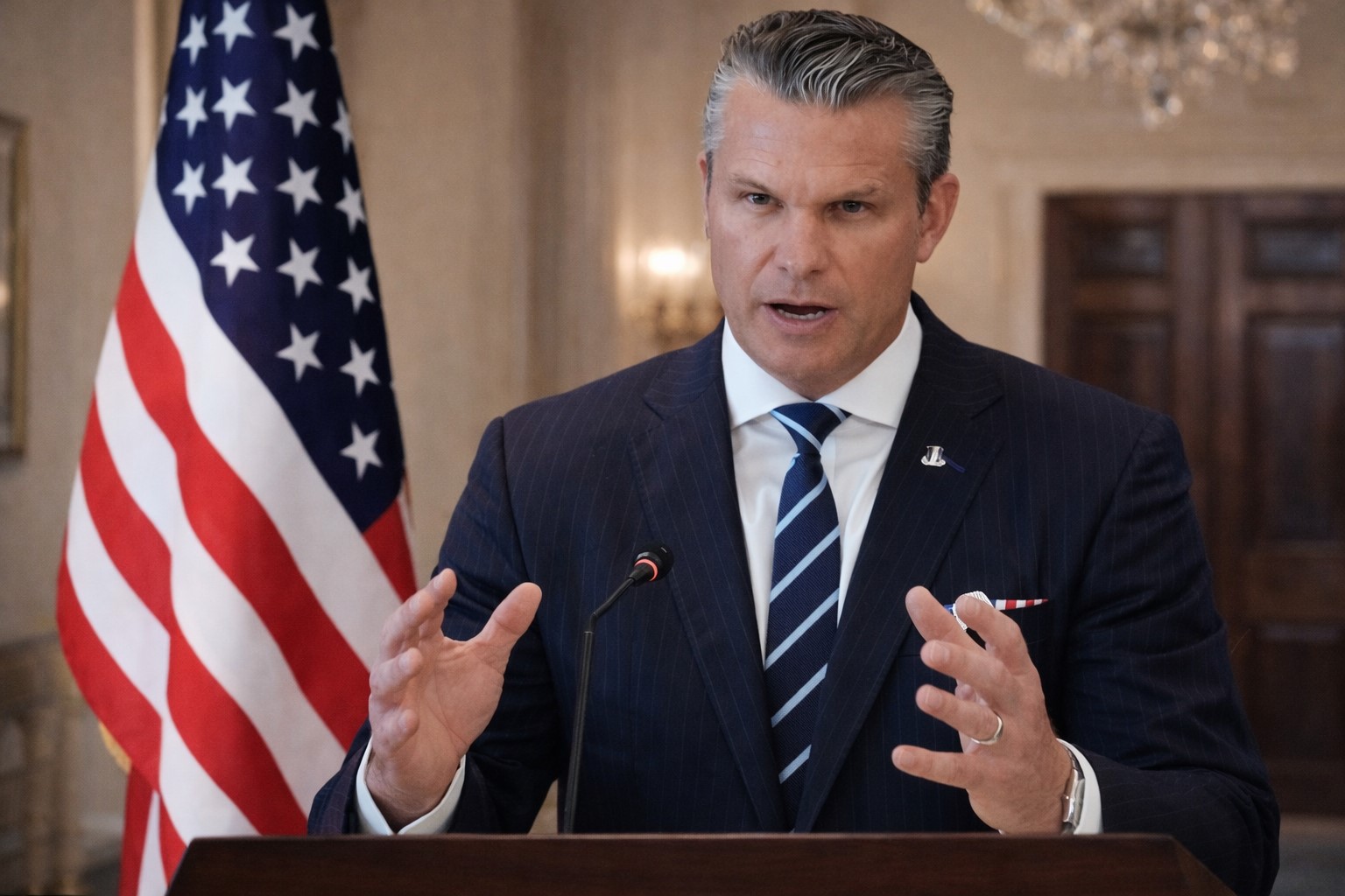 Ilustração mostra Pete Hegseth em discurso na Casa Branca.