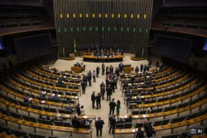 Montagem fotográfica ultra-realista gerada por IA mostra o plenário da Câmara dos Deputados, em Brasília, durante uma sessão com parlamentares no interior da Casa.