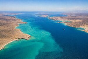 Vista aérea do Estreito de Ormuz com apenas um navio em cenário de baixa movimentação marítima.