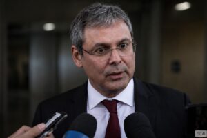 Montagem fotográfica ilustrativa gerada por IA mostra o deputado federal Lindbergh Farias falando com a imprensa em ambiente interno institucional.