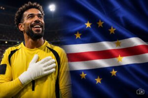 Montagem fotográfica realista mostra o goleiro Vozinha, de Cabo Verde, sorrindo em ambiente alusivo a um estádio de Copa do Mundo, ao lado da bandeira cabo-verdiana em destaque.