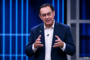 Representação fotorrealística gerada por IA de Augusto Cury em cenário de debate, utilizada para contextualizar notícia sobre sua terceira posição em pesquisa de intenção de voto