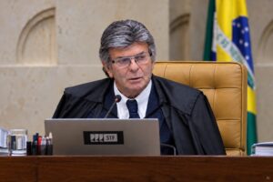 Representação gerada por IA de Luiz Fux em ambiente alusivo a sessão do STF, com toga, microfone e estrutura institucional ao fundo.